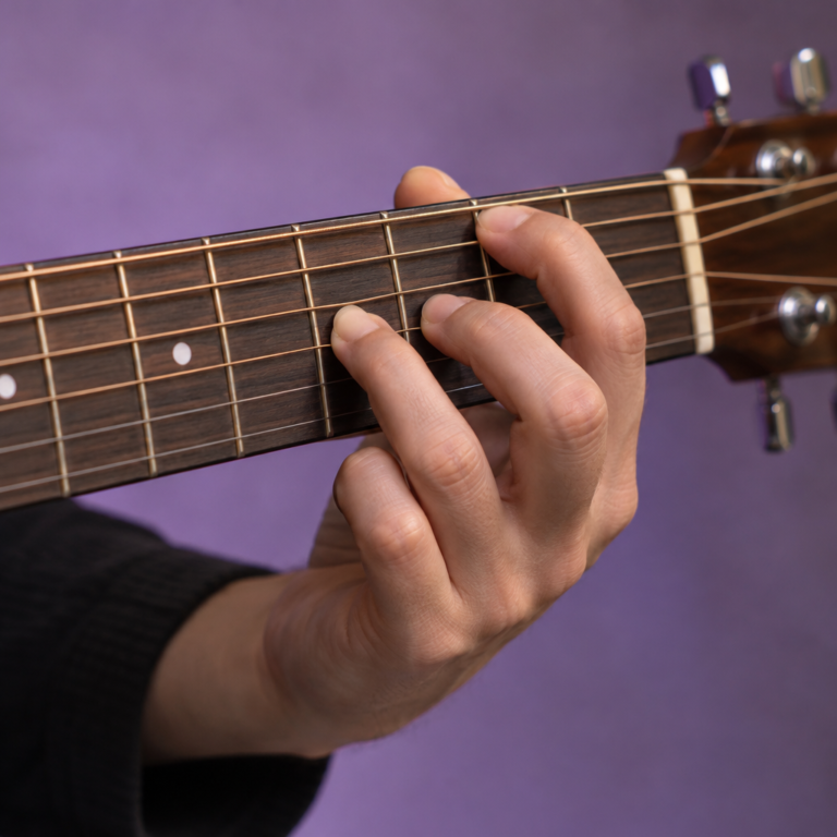 Close-up of a hand fretting a chord on the neck of an acoustic guitar
